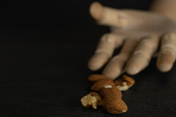 Lot of whole brown almond nut with wooden arm isolated on grey stone