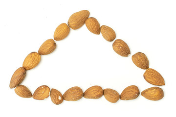 Lot of whole brown almond nut triangle flatlay on white background