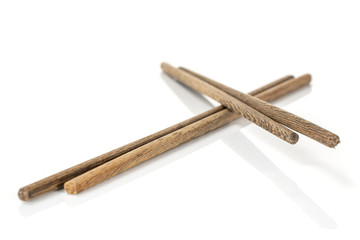Group of four whole crossed asian brown chopsticks isolated on white background