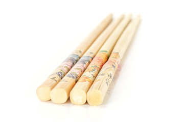 Group of four whole asian brown chopsticks in row isolated on white background