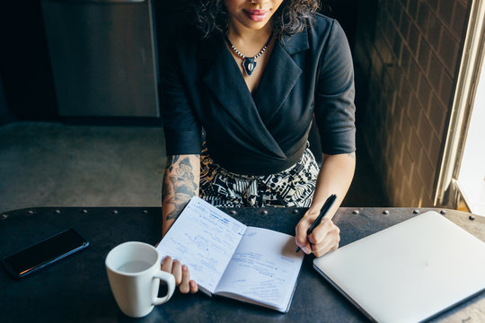 Young businesswoman writing notes in diary