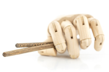 Group of two whole dark asian brown chopsticks with wooden hand isolated on white background