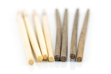 Group of eight whole asian brown chopsticks in row isolated on white background