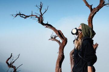 Young woman in breath filter mask to protect from toxic gas and poisonous fumes during adventure...