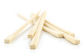 Group of six whole crossed asian brown chopsticks isolated on white background