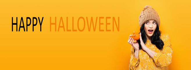 Happy Halloween with young woman holding a pumpkin