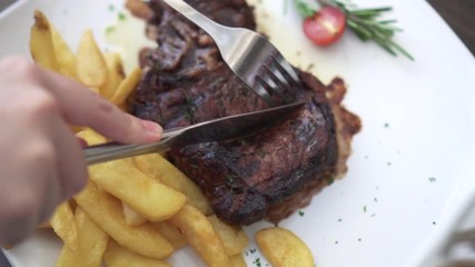 Beef steak and fries knife cutting