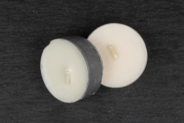 Group of two whole waxy white tea candle flatlay on grey stone