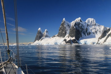 jacht na zimnych wodach okołobiegunowych z antarktydą w tle w słoneczny dzień