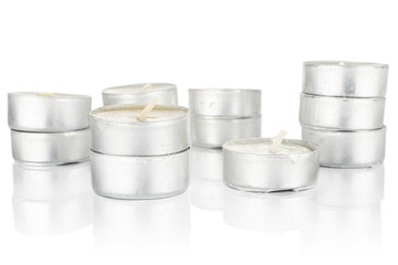Lot of whole light waxy white tea candle stack isolated on white background