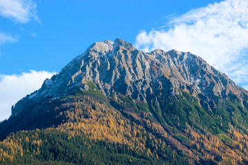 Scenic view of autumn alps mountains under bright blue sky