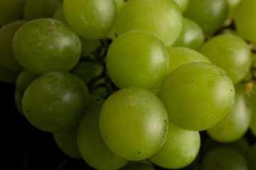 Lot of whole fresh green grape isolated on black glass