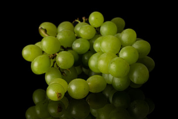 Lot of whole fresh green grape cluster isolated on black glass