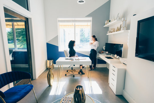 Overhead view of two young businesswomen in modern office space