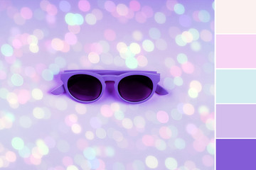 Ultra violet sunglasses on purple background with colorful light bokeh. Minimal trendy festive...