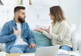 Young couple arguing about domestic bills at home