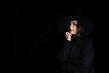 Fototapeta premium Portrait of beautiful asian woman wear witch costume on black background,Thailand people,Halloween festival concept,Horror scene