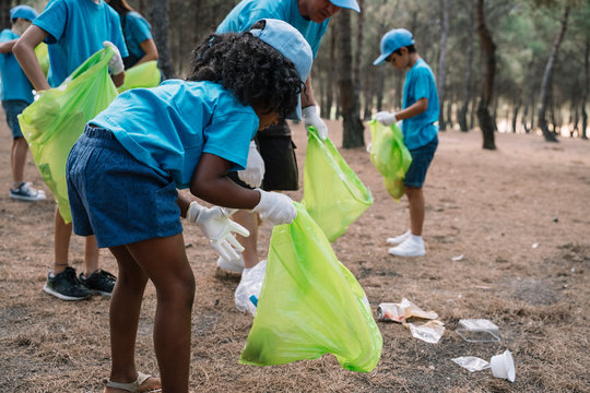 Group of volunteering children collecting garbage in a park