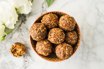 Energy protein balls with healthy ingredients on marble table. Home made with dates, peanut butter, flax and chia seeds, oats, almond and chocolate drops - 291777899