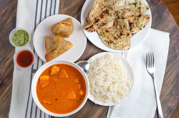 Chicken tikka masala, rice, samosas and naan-Indian cuisine overhead view