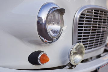 Headlight of a vintage retro car of gray color, close-up.