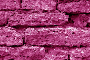 Old grungy brick wall texture in pink tone.