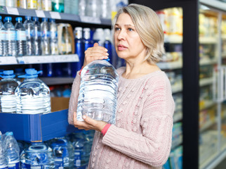 Adult woman looking for water in bottles