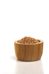 wooden bowl of buckwheat isolated on white background. Image contains copy space