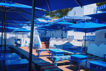 Arabic open-air cafe with blue umbrellas and white walls, Sidi Bou Said, Tunisia