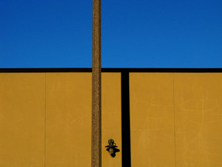 Shadow of Pole on Yellow Building. Concept of Trapped Feeling. Architectural Background. Copy Space for Walls and Borders.