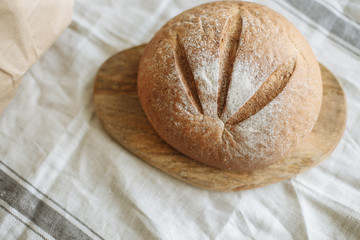 Loaf of bread on a board on a white tablecloth