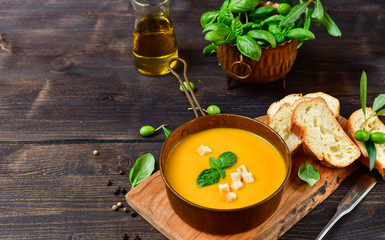 pumpkin soup and bread with basil and crispy crackers, vegan recipe. Autumn cream soup of seasonal...