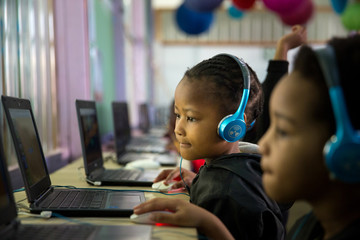 School girl child sitting and concentrating at a laptop