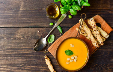 pumpkin soup and bread with basil and crispy crackers, vegan recipe. Autumn cream soup of seasonal product