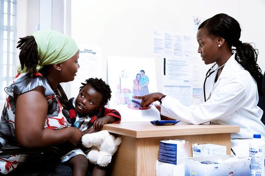 African mother and her child sitting with a doctor for a consultation