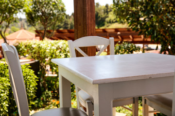 White wooden table and blurreed background of summer garden 