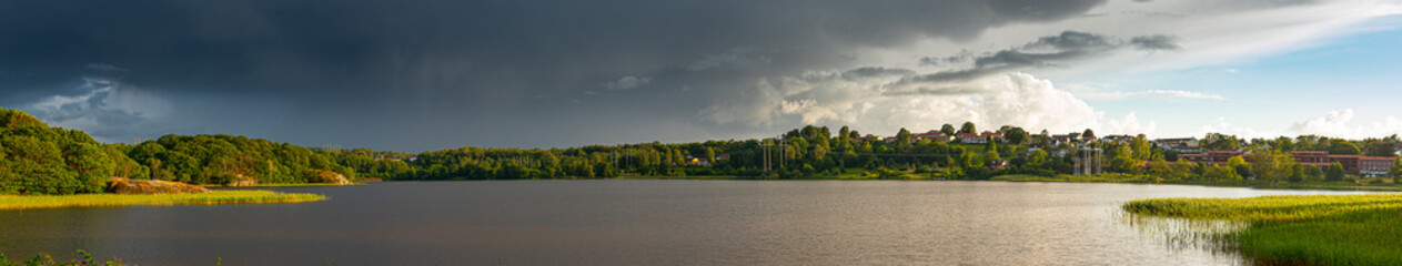 Obraz premium Wide panorama over a lake with power lines going across on the far shore.