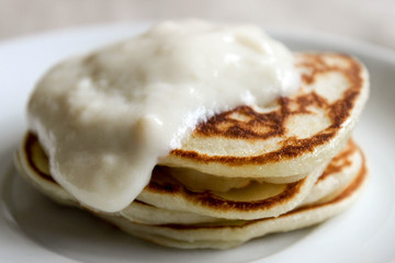 Fresh hot flapjack pancakes stack on white plate on natural light linen tablecloth background. Soft focus. Copy space. Pancake carnival maslenitsa breakfast concept