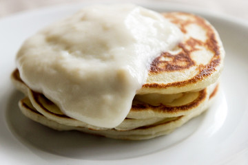 Fresh hot flapjack pancakes stack on white plate on natural light linen tablecloth background. Soft focus. Copy space. Pancake carnival maslenitsa breakfast concept