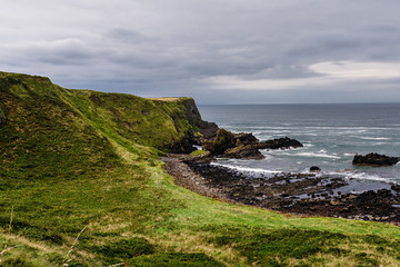 Fototapeta na wymiar Ireland - coast view, green landscape, rough coasts, cliffs, monastery, graveyards and cloisters