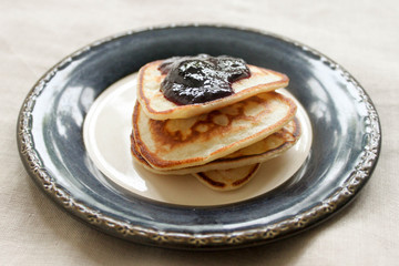 Stack of homemade shrovetide carnival pancakes on blue plate on rustic country table. Soft focus. Copy space. Pancake carnival maslenitsa breakfast concept