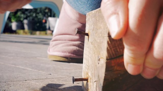 Woman working wood hitting with hammer