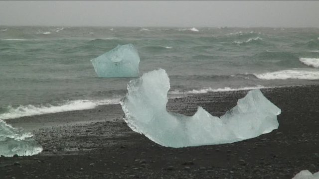 Medium shot, eroded glacial ice chunk on Iceland beach