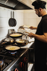 Professional chef working in restaurant kitchen and making delicious traditional food.
