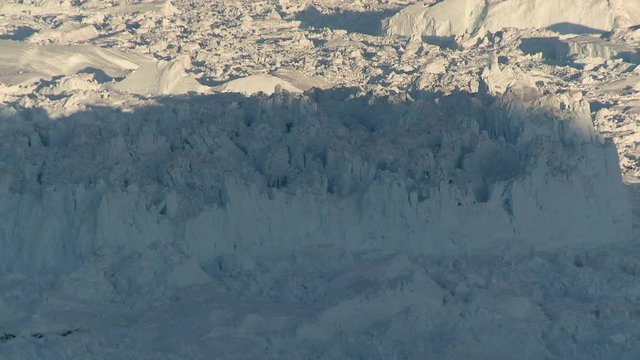 Sun begins to set over glacier, high angle