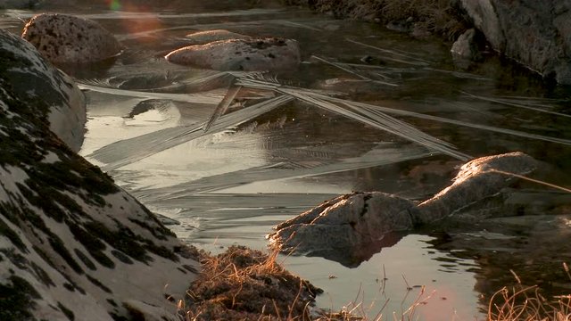 Zoom out, frozen water source in remote mountains