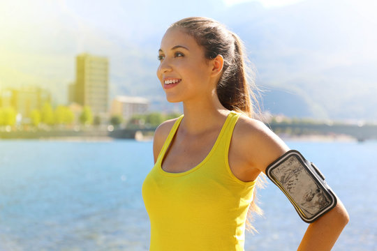 Fitness woman with arm band for phone technology doing running marathon exercise jogging stretching warm in the morning in city lake. - Powered by Adobe
