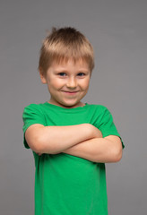 Portrait of happy smiling boy in green t-shirt. Attractive kid in studio. Childhood concept.