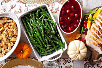 Thanksgiving dinner table with sliced turkey and sides, overhead shot