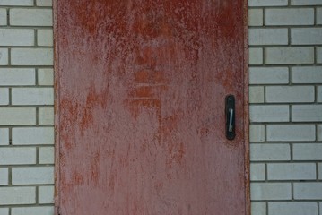 red metal door on a gray brick wall of a building